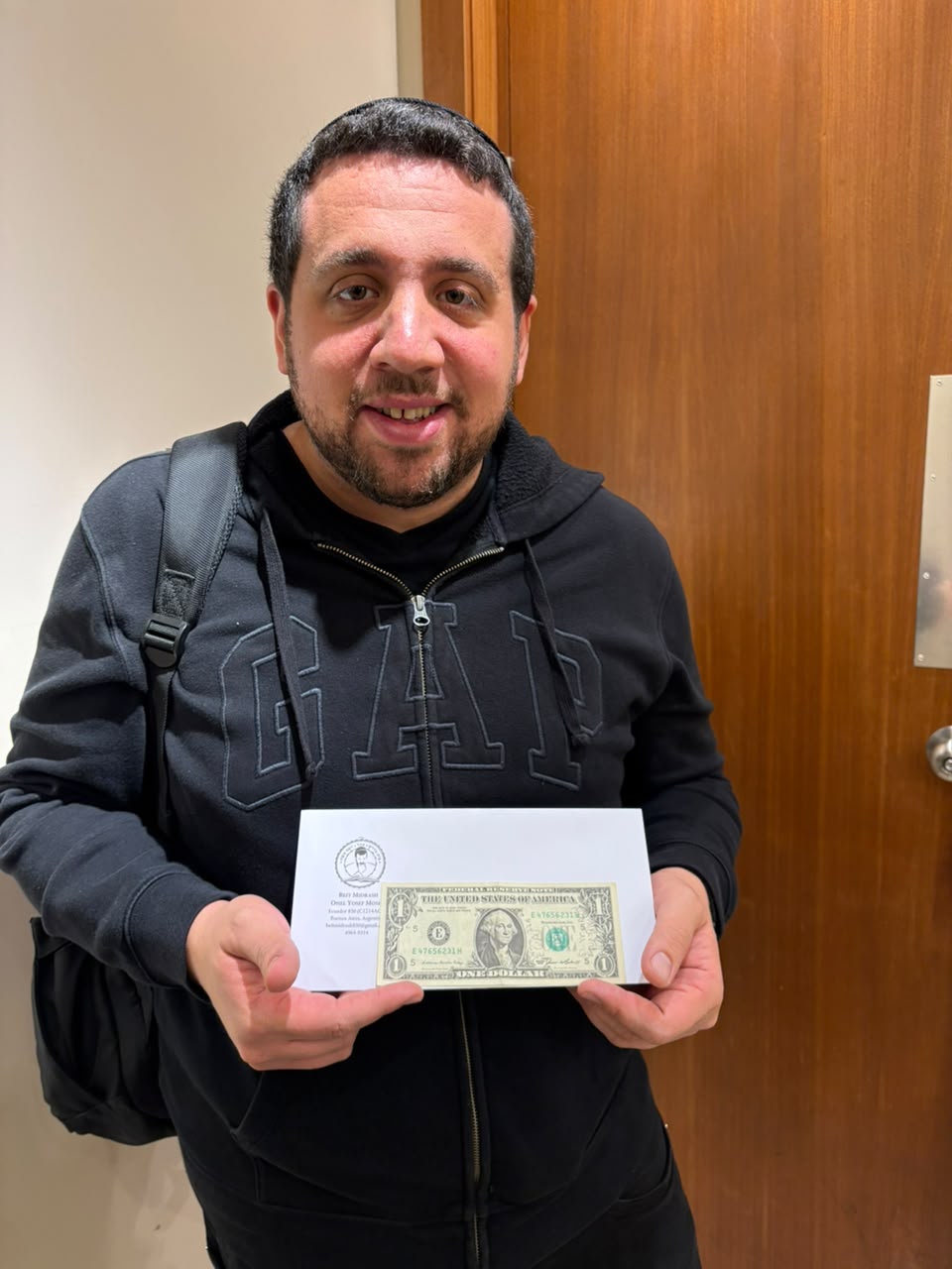 Daniel Piperno muestra el dólar del Rebe recibido.